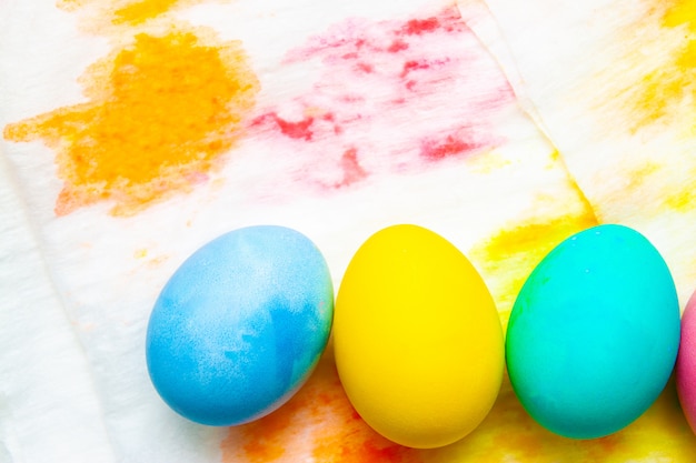 Foto frontera colorida del marco de los huevos de pascua en fondo pintado multicolor.