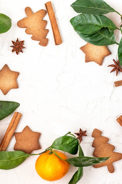 Foto frontera de navidad estrella galletas con especias y mandarina sobre fondo blanco con copyspace.