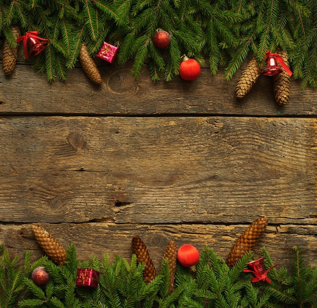 Foto frontera de navidad con ramas de abeto conos y decoraciones navideñas en tablas de madera rústicas listas para su diseño