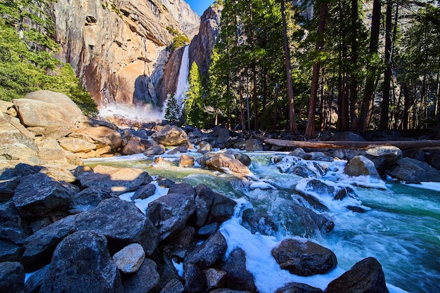 Frostige blaue Flüsse, die über die Felsen von Lower Yosemite Falls in Kalifornien stürzen