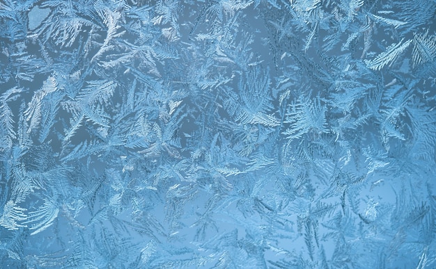 Frostiges Muster auf der Fensterscheibe. Winterblaue Wand