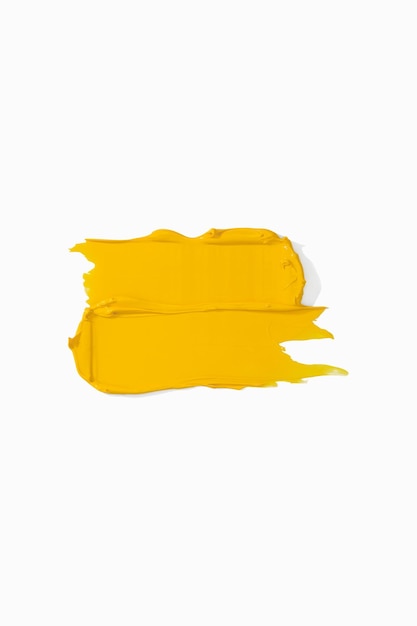 Frotis y textura de pintura acrílica aislada sobre fondo blanco Textura de crema Muestra de deslizamiento de pincel de producto de pintura de color amarillo brillante