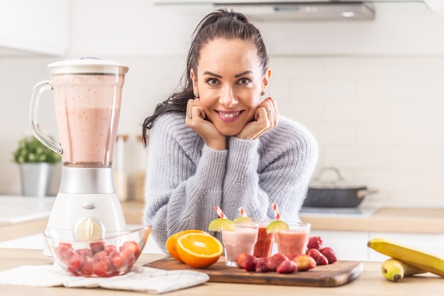 Fruchtbasierte Ernährung, die von einer Frau zu Hause hergestellt wird, indem Beeren und Zitrusfrüchte zu einem Smoothie gemischt werden.