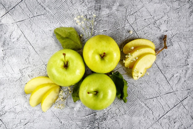 Foto fruchtige fantasie drei ganze grüne äpfel und apfelschnitze. nahansicht. veganes essen, gesunder lebensstil.