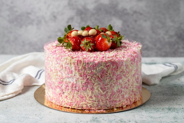 Fruchtkuchen auf grauem Hintergrund Erdbeeren, Banane und Schokolade Geburtstags- oder Feierkuchen Bäckereidesserts in naher Nähe