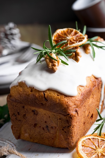 Fruchtkuchen wischte mit Zuckerglasur, Nüssen und trockener orange Nahaufnahme ab. Weihnachts- und Winterferien hausgemachten Kuchen