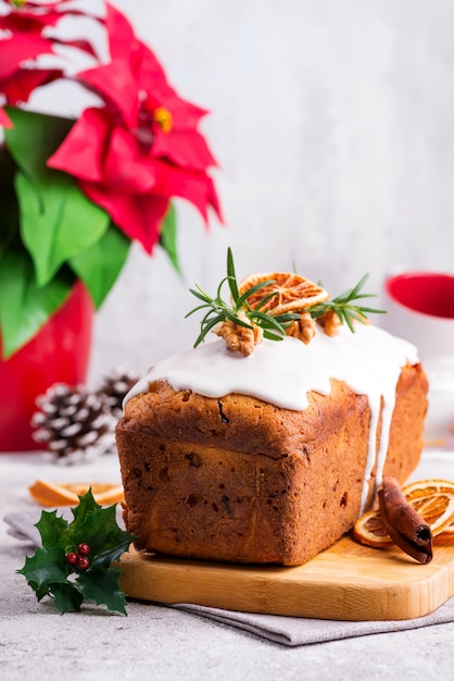 Fruchtlaibkuchen wischte mit Zuckerglasur, Nüssen und trockener Orange auf Stein ab. Weihnachts- und Winterferien Weihnachtsstern auf