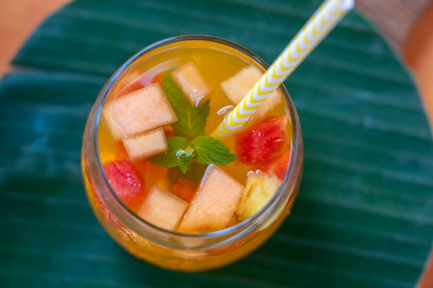 Fruchtlimonade aus roten Erdbeeren Melonen und Ananas in einem Glas Nahaufnahme Erfrischungsgetränk aus Fruchtstücken