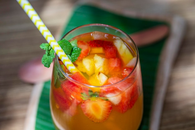 Fruchtlimonade aus roten Erdbeeren Melonen und Ananas in einem Glas Nahaufnahme Erfrischungsgetränk aus Fruchtstücken