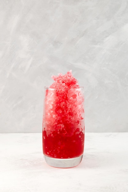 Fruchtrasiertes Eis im hohen Glas Slush-Getränk auf grauem Hintergrund Erfrischendes Sommergetränk