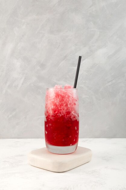 Fruchtrasiertes Eis mit natürlichem Saft Roter Slushie-Drink auf grauem Hintergrund Granizado-Sommergetränk.