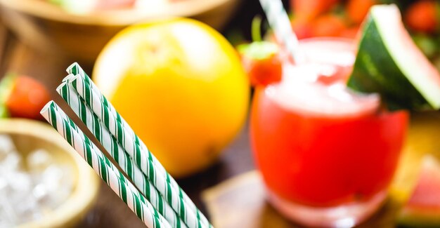 Foto fruchtsaft serviert mit einem papierstrohhalm, punktueller fokus auf dem strohhalm, biologisch abbaubares material ohne plastikfolie