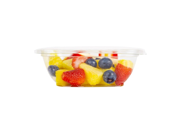 Fruchtsalat mit Ananas, Erdbeeren und Blaubeeren in einem Plastikbehälter auf weißem Hintergrund