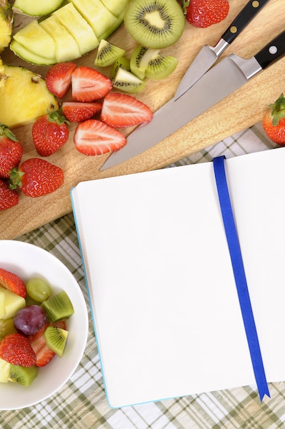 Foto fruchtsalat mit blauem kochbuch