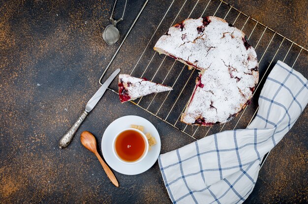 Fruchttorte und Tee auf einem Holztisch