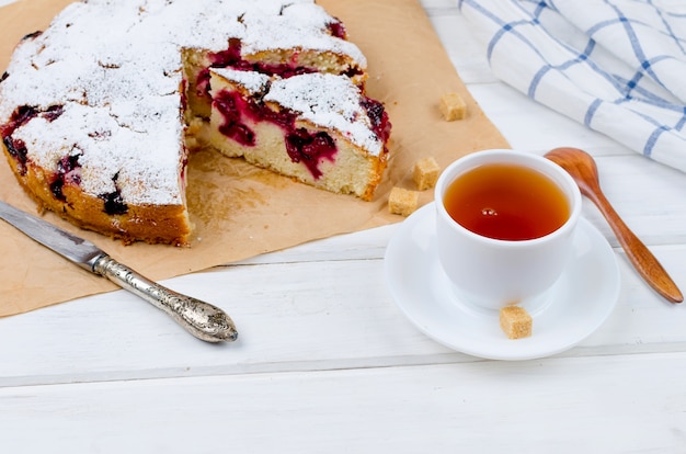 Fruchttorte und Tee auf Holztisch