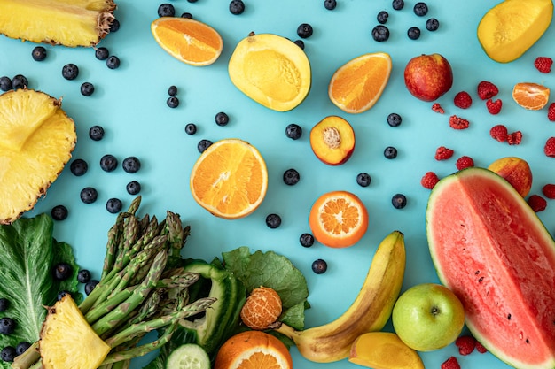 Früchte, Beeren und Gemüse auf blauem Hintergrund