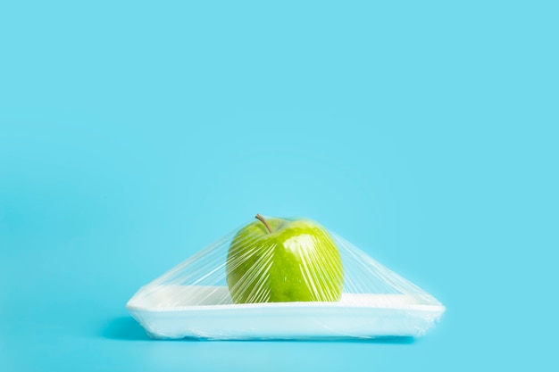 Früchte in Plastikverpackungen aus dem Supermarkt sind minimaler Apfel in Zellophan und nicht abbaubare...