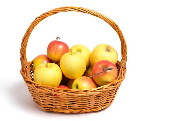 Früchte, Äpfel und Mandarinen in einem Weidenkorb auf weißem Hintergrund.