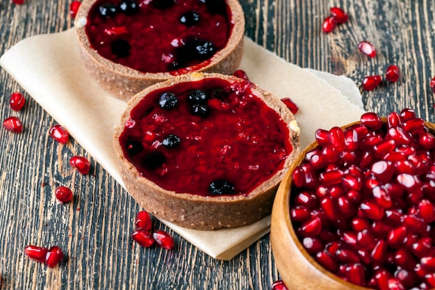 Früchte- und Beerenkuchen-Törtchen mit Sahne, Granatapfelkernen und Früchte-Törtchen mit süßer Sahne