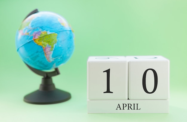 Frühling 10 April Kalender. Teil eines Sets auf unscharfem grünem Hintergrund und Kugel.