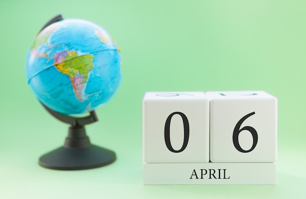 Frühling 6. April Kalender. Teil eines Sets auf unscharfem grünem Hintergrund und Kugel.