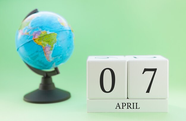 Frühling 7. April Kalender. Teil eines Sets auf unscharfem grünem Hintergrund und Kugel.