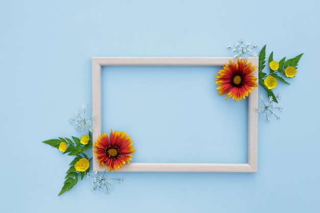 Frühling, Blumenhintergrund. Blumenarrangement. Rahmen mit gelb-orange Blumen auf einem hellen Hintergrund.