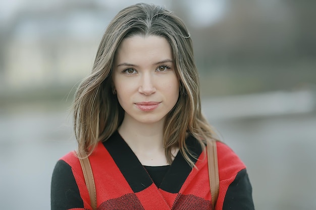 Frühling erwachsenes Mädchen im Freien / März in Schottland, ein Mädchen in einem Plaid posiert im Park