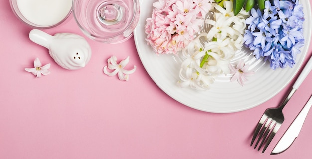 Frühling festliche Tischdekoration mit Hyazinthenblumen auf rosafarbenem Hintergrund.