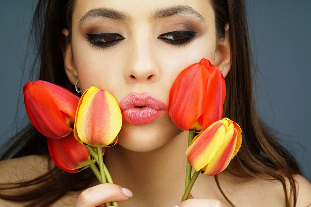 Frühling Frau Modekonzept Frauentag 8. März Mode Schönheit Mädchen mit Tulpenfeldern Close up Portrait