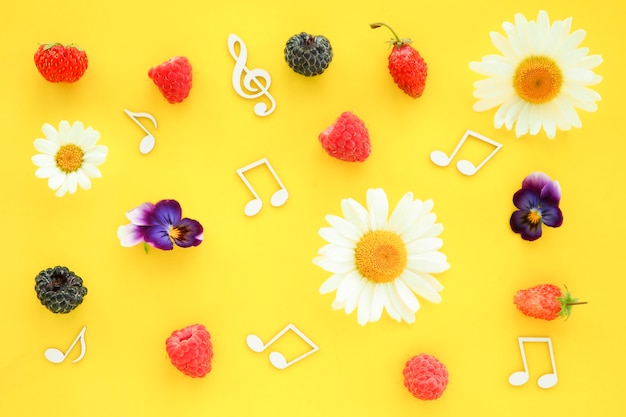 Frühling Hintergrund Violinschlüssel und Musiknoten mit Blumen und Beeren auf gelbem Grund.