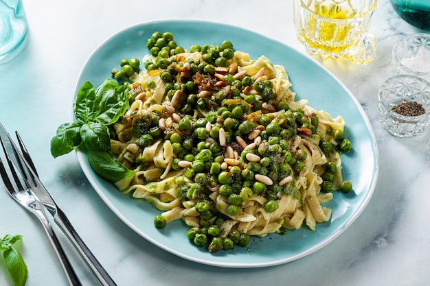 Frühlings hausgemachte italienische Pasta mit Kichererbsenmehl und Pesto mit frischen grünen Erbsen und Pinienkernen.