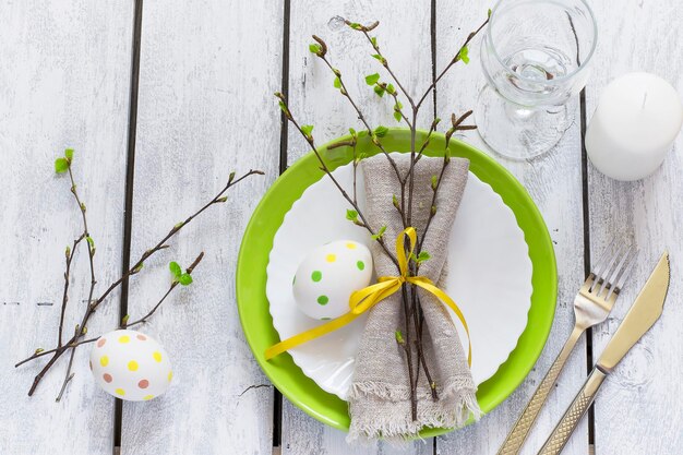 Frühlings-Ostern-Tabelleneinstellung an der Draufsicht des weißen Holztischs