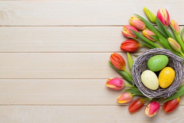 Frühlings-Ostertulpen im Eimer auf weißem Weinlesehintergrund.