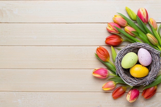 Frühlings-Ostertulpen im Eimer auf weißem Weinlesehintergrund.