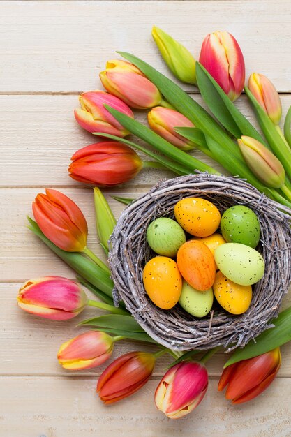 Frühlings-Ostertulpen im Eimer auf weißer Weinleseoberfläche.