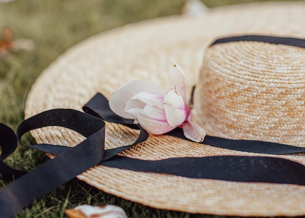 Frühlingsblüte Eine offene Blende mit einer leichten Unschärfe Ein Womans Strohhut mit großer Krempe und einer darauf liegenden Magnolienblüte Frühling