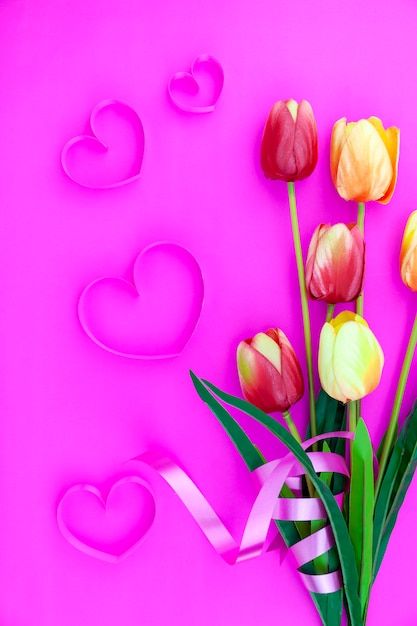 Frühlingsblume von multi Farbentulpen auf rosa Hintergrund, Flachlagebild für Feiertagsgrußkarte für Muttertag, Valentinstag, Frauentag und Kopienraumraum für Ihren Text