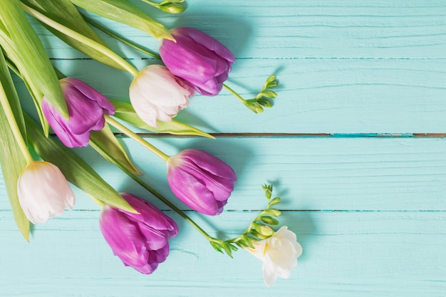 Frühlingsblumen auf hölzernem Hintergrund der blauen Minze