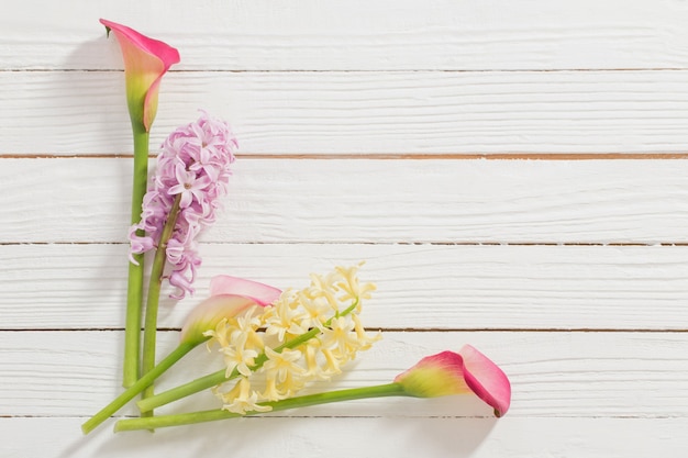 Frühlingsblumen auf weißer Holzoberfläche