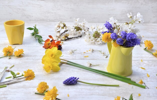 Frühlingsblumen aus dem Garten gepflückt und auf einem Tisch angeordnet, um zu Hause einen Blumenstrauß zu machen