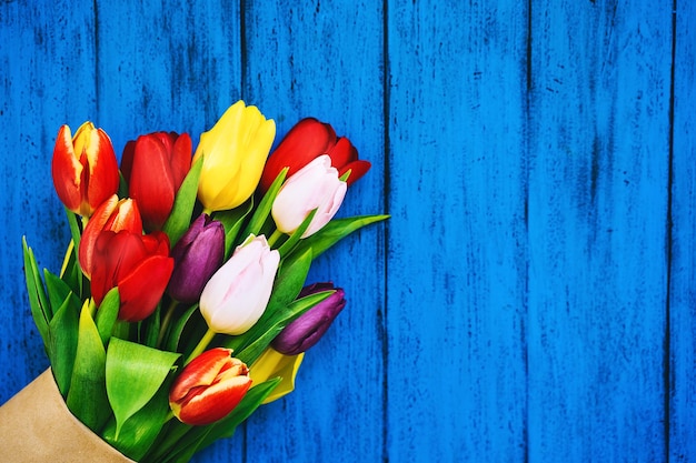 Frühlingsblumen Blumenstrauß Schöne Tulpen auf rustikalem Holz in heller Farbe türkisblauer Hintergrund Flach liegend Draufsicht Kopierraum