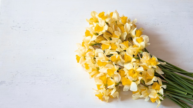 Frühlingsblumen Narzissen auf einem Holztisch.