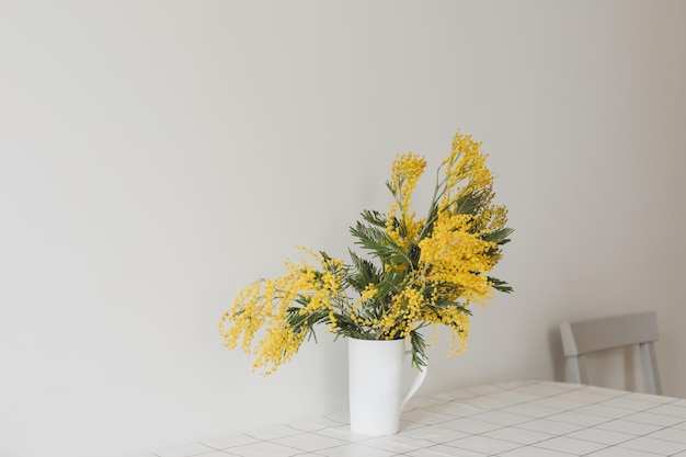 Frühlingsblumenzusammensetzung gelbe Mimosenblumen auf weißem Hintergrund im Hauptinnenraum