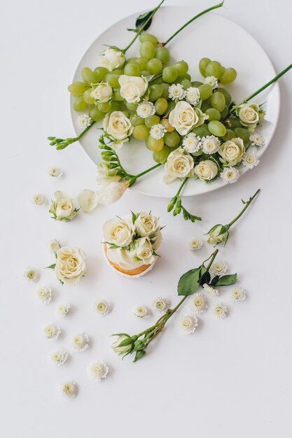 Frühlingscupcake auf einem Weiß mit Blumen und Früchten aro