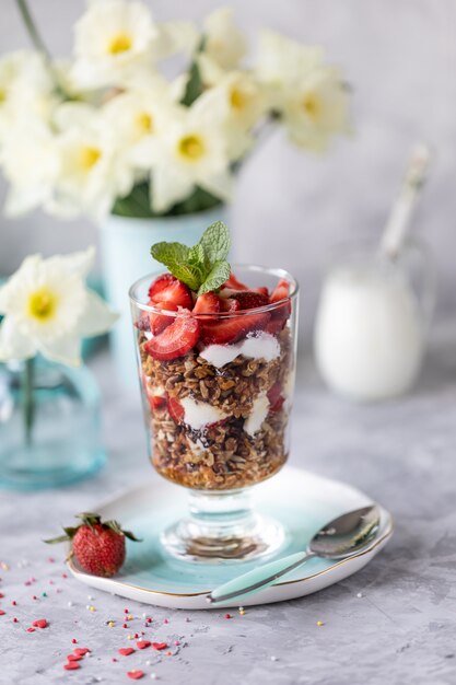 Frühlingsfrühstück mit Blumen, Käsekuchen und frischen Beeren