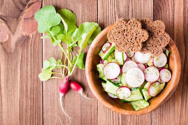 Frühlingsgemüsesalat in einer hölzernen Platte