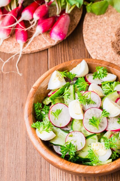 Frühlingsgemüsesalat in einer hölzernen Platte