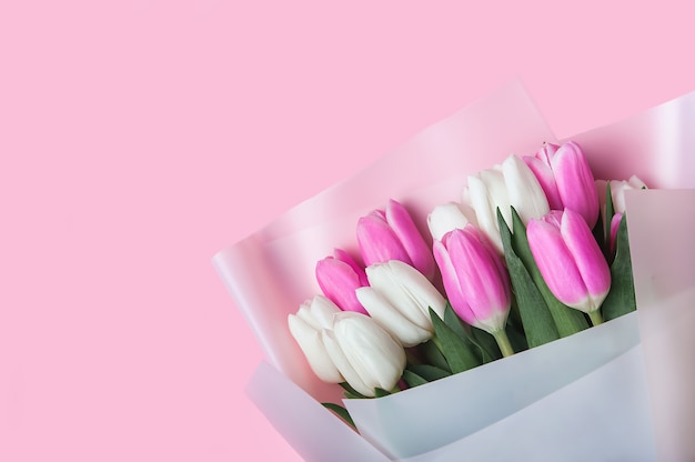 Frühlingshintergrundkarte Rosa und weiße Tulpen in pastellrosa Hintergrundnahaufnahme Frische Blumen für horizontale Blumenplakattapete oder Postkarte Ostern-Banner-Grußkarte Textfreiraum